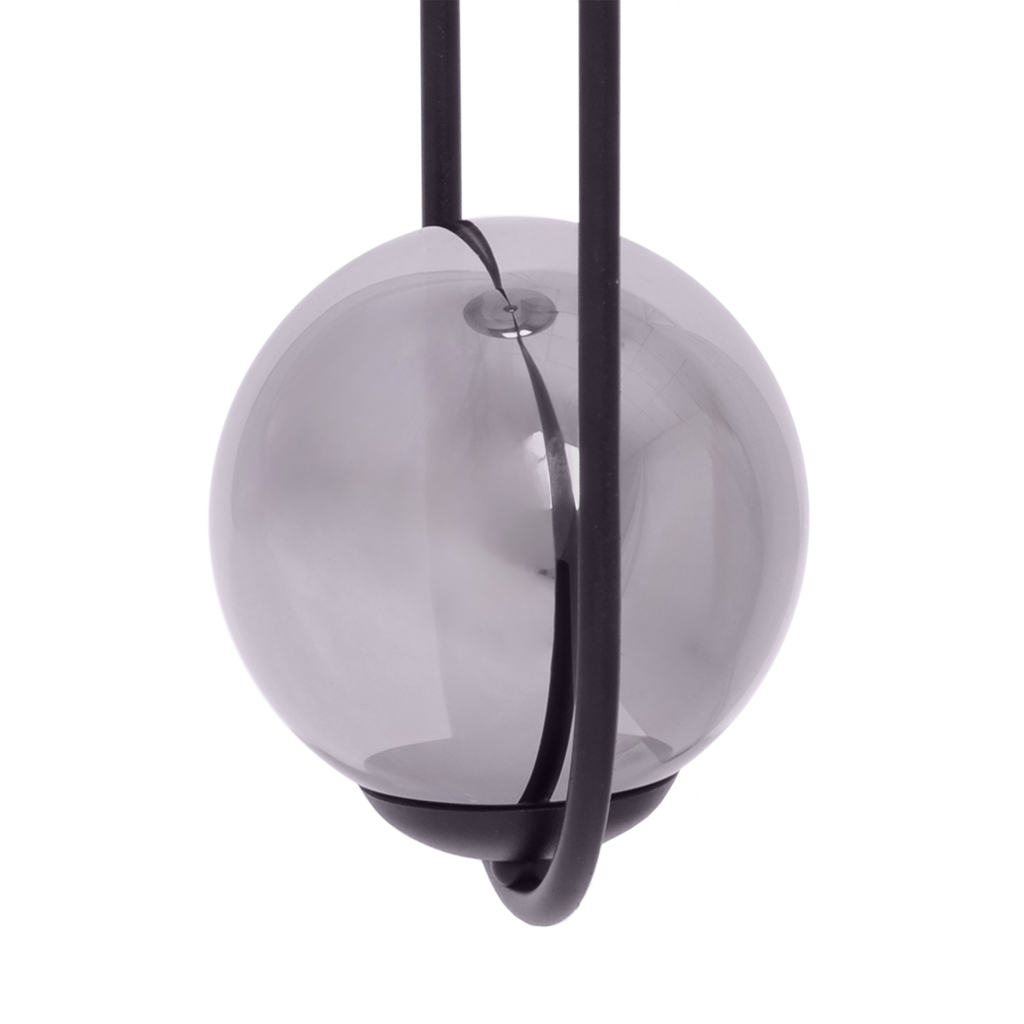 Grafitowy klosz lampy został wkomponowany w oprawę o kształcie elipsy w czarnym kolorze.
