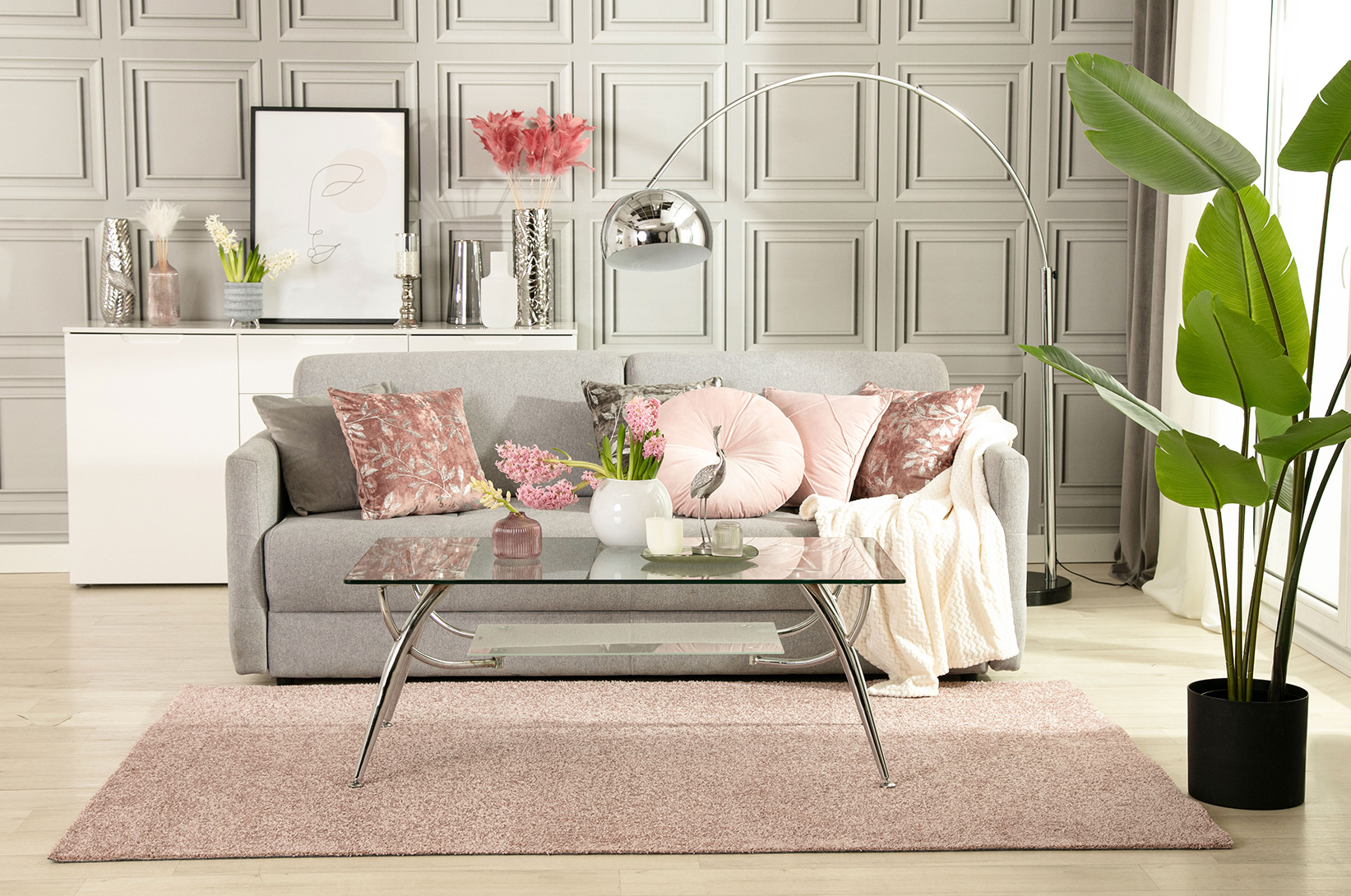 Aranżacja szarej kanapy z różowym dywanem