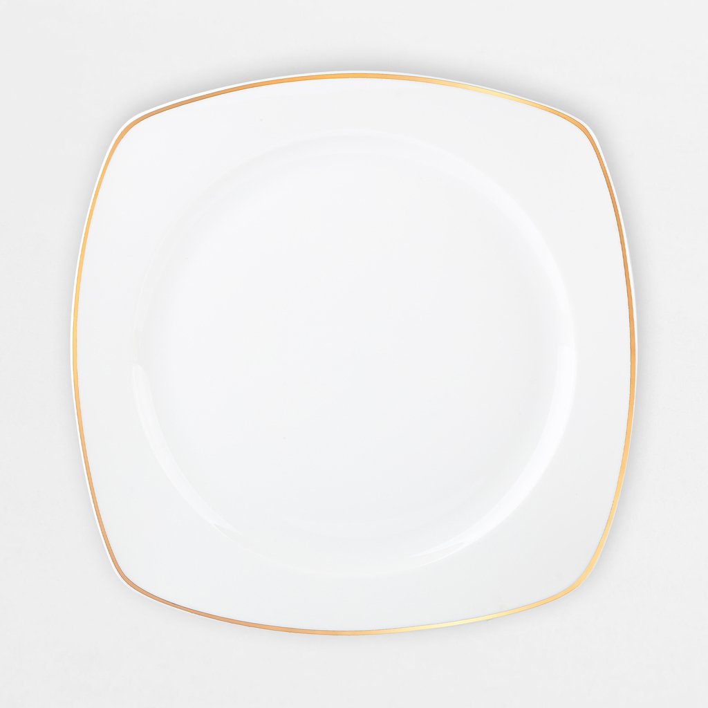 Zestaw obiadowy z białej porcelany o geometrycznym kształcie. Ma pozłacane brzegi.